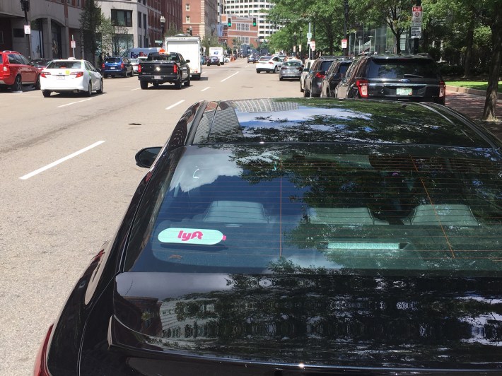 A double-parked Lyft driver waits outside of the South Station bus terminal on Thursday, August 8, 2019.