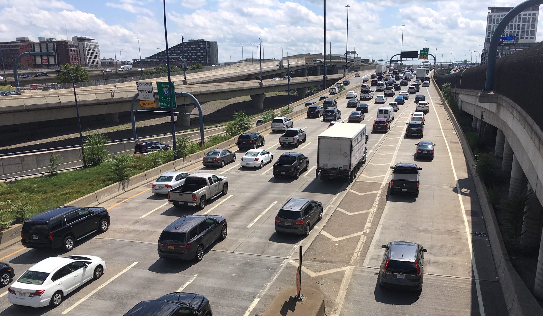 About 40 cars occupy five lanes of highway in crawling traffic that stretches off to the horizon..