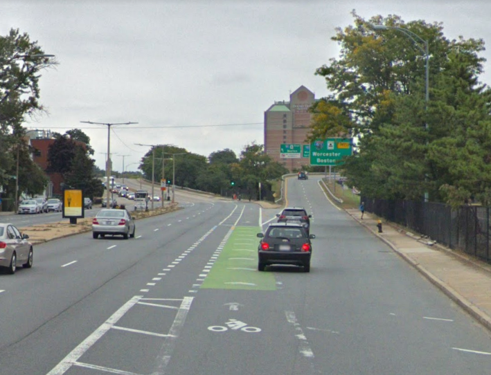 The current eastbound bike lane on Cambridge Street in Allston weaves through four lanes of high-speed traffic where a Turnpike on-ramp diverges. The City of Boston and MassDOT are planning physical separation and a road diet for the on-ramp in order to give cyclists a safer passage through the area. Image courtesy of Google Street View.