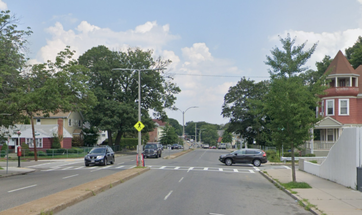 Crosswalks on Cummins Highway in Mattapan currently span across four lanes of traffic with small median in the center of the roadway. A plan from the Boston Public Works Department aims to improve safety and reduce speeding by reducing the street to one lane in each direction, similar to the street's layout in nearby Roslindale. Image courtesy of Google Street View.
