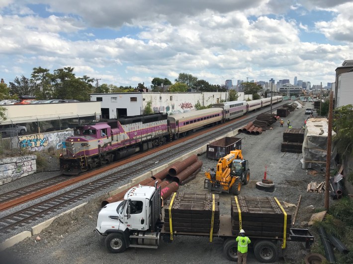 The Green Line Extension under construction next to a Lowell Line commuter rail train, seen from the Cross Street overpass in East Somerville on Oct. 1, 2020.