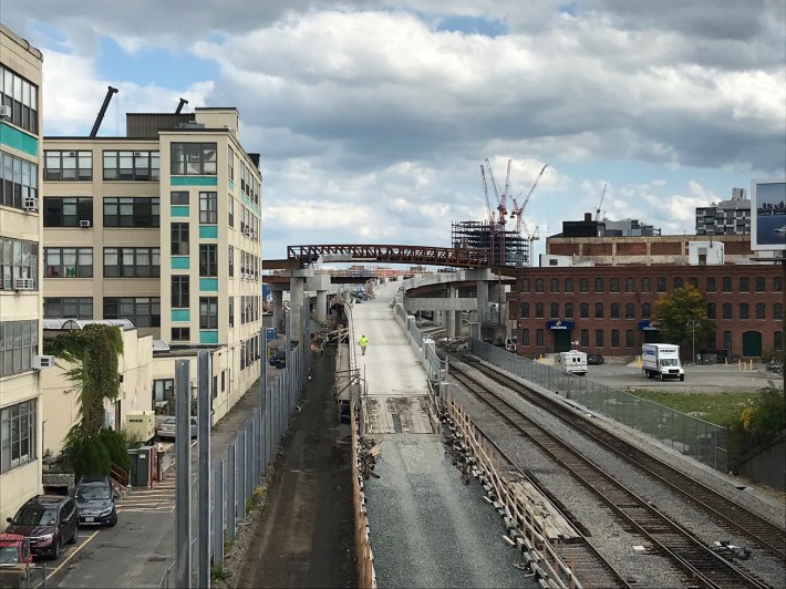 A view east from the McGrath Highway shows the future path of the Union Square branch of the Green Line extension (center, foreground) and the truss viaduct of the Community Path. In the background is the junction where the two branches of the Green Line extension will meet.