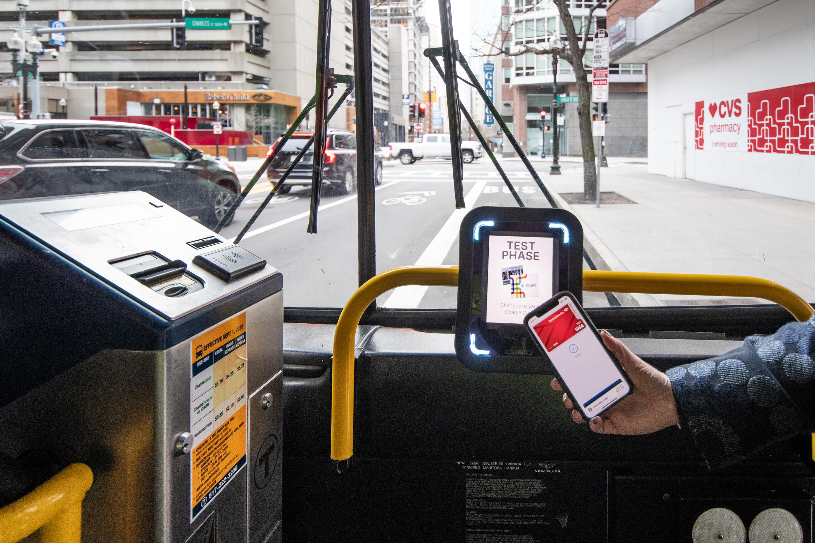 A bus rider pays their fare with their phone during a test of the T's new fare system on an MBTA bus in downtown Boston in January 2021.
