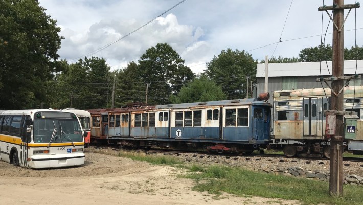An old Blue Line train and MBTA bus await restoration at the Seashore Trolley Museum.