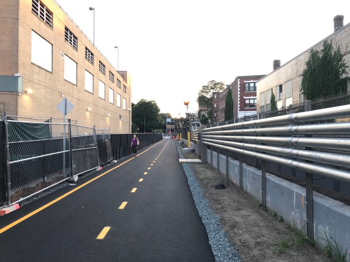 The first phase of the new Fenway multi-use path runs parallel to the Green Line tracks (at right) behind the Landmark Center (at left).