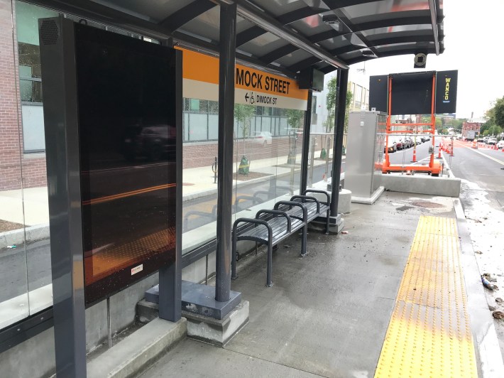 A close-up view of the large real-time information screen inside the Dimock Ave. bus stop.