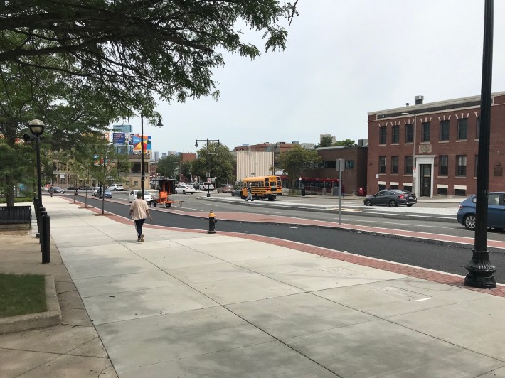 The new sidewalk and protected bike path on Warren Street in Nubian Square, next to the Roxbury Branch of the Boston Public Library.