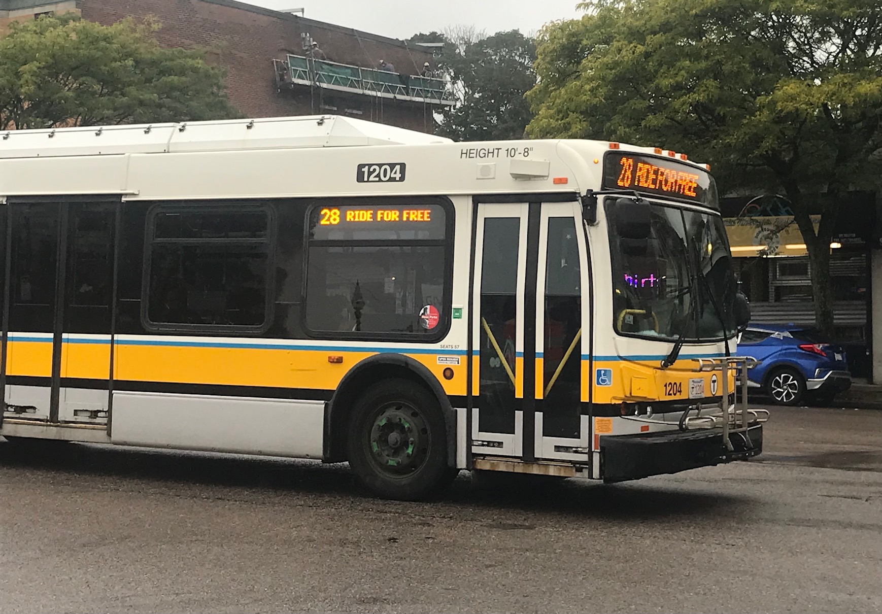 A route 28 bus advertising the fare-free pilot passes through Grove Hall on Blue Hill Avenue on October 5, 2021.