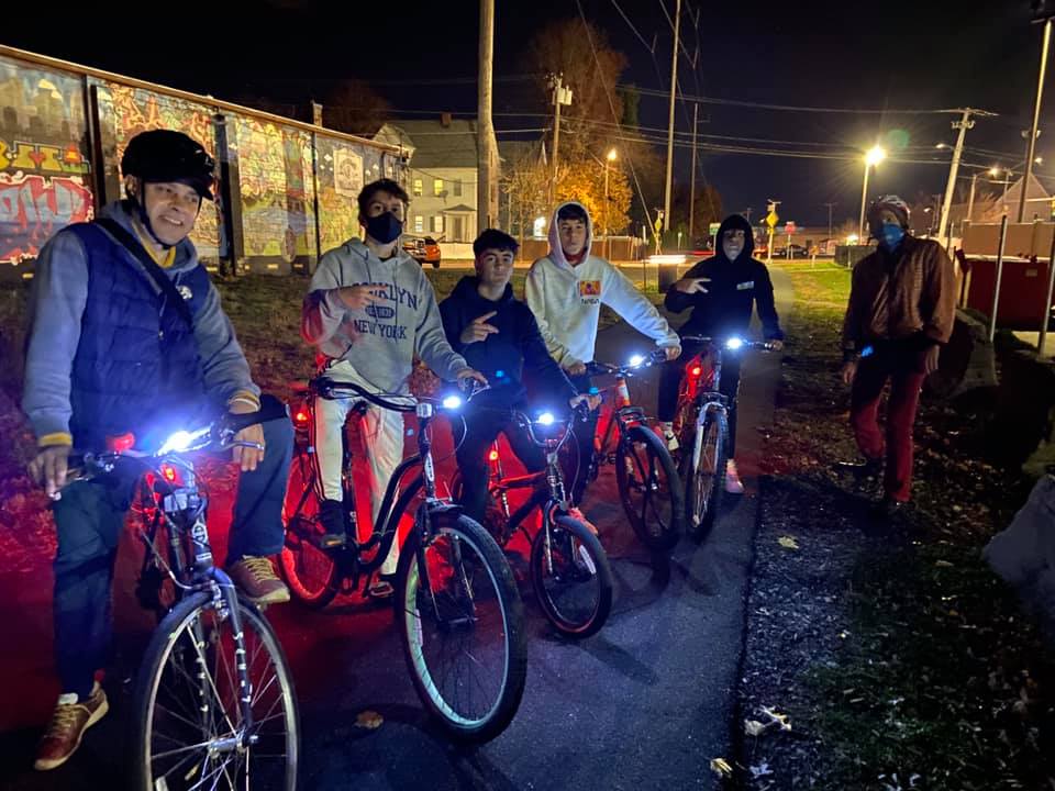 Riders on a bike path show off their new bike lights.