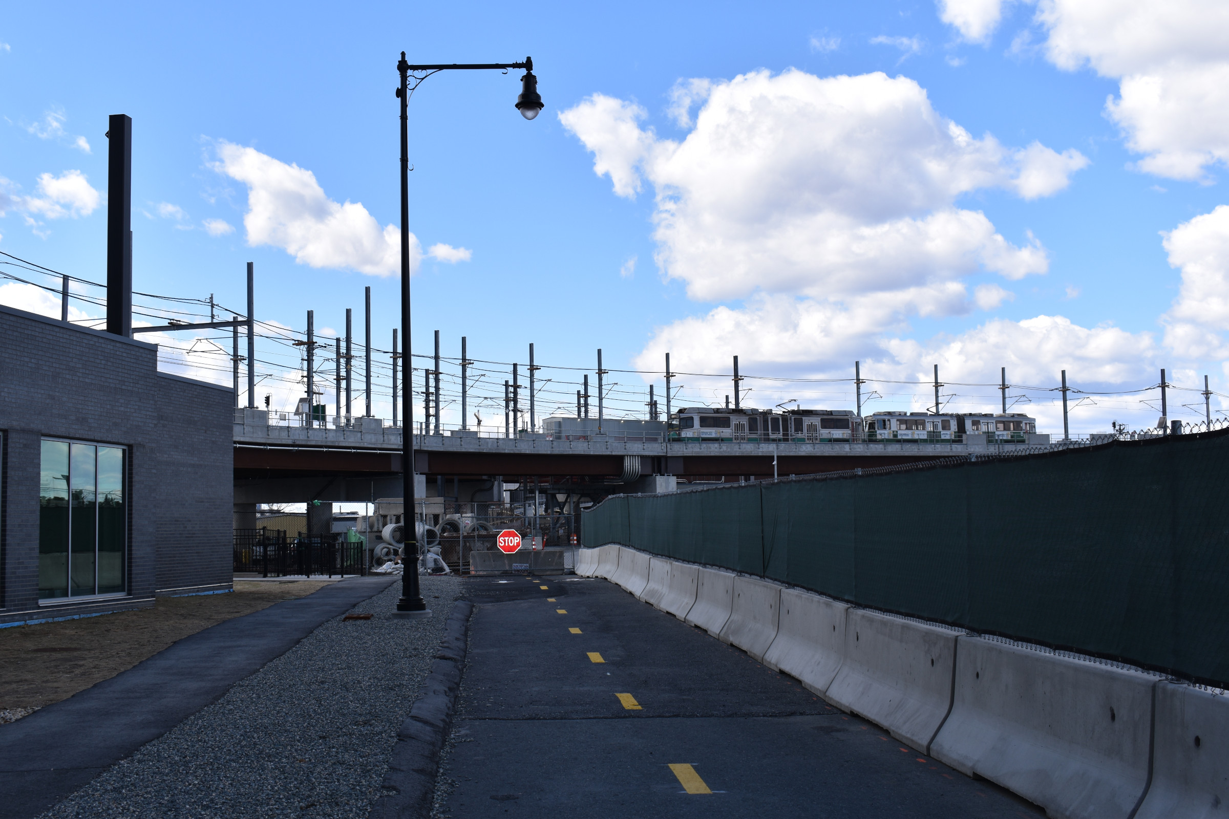 A Green Line train passes over the viaduct over the future Community Path west of Lechmere Station