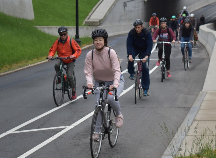 Amy Li (foreground) rides in a convoy of bicyclists in a bike lane on Commonwealth Avenue near the Massachusetts Avenue underpass.