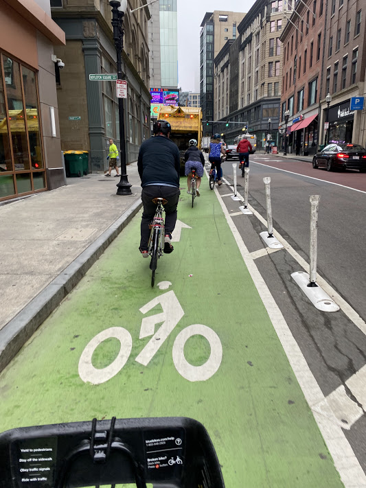 people biking on a separated bike line on Washington St towards downtown for Bike to Work Day