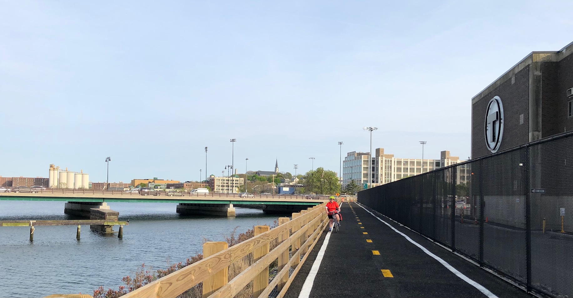 The new Charlestown Seawall bike path, looking south towards the Alford Street bridge. The Mystic River is on the left and the MBTA's Charlestown bus garage is located behind a high chain-link fence on the right.