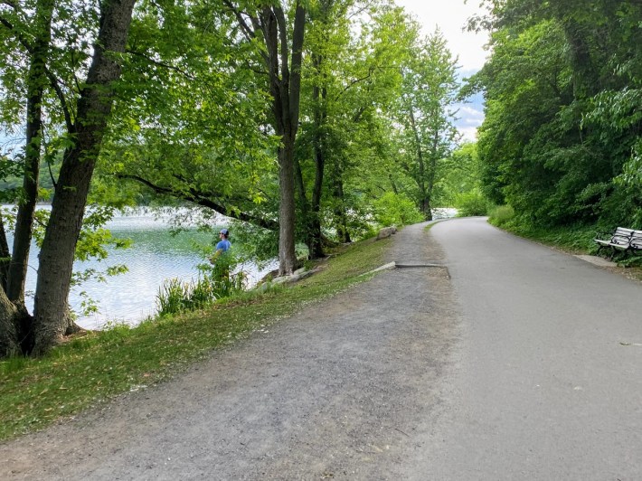 A man enjoying an evening of fishing along the edge of Jamaica Pond, part of the Emerald Necklace and the Walking City Trail.