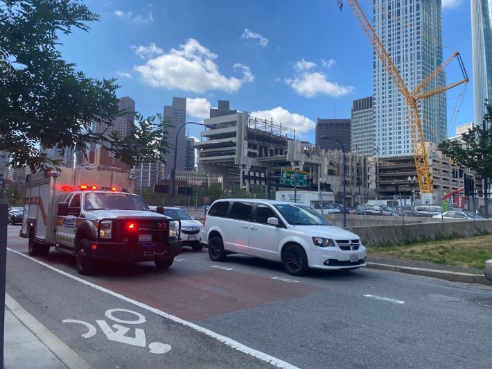 Ambulance riding down Cross Street with the Government Center garage in the background.