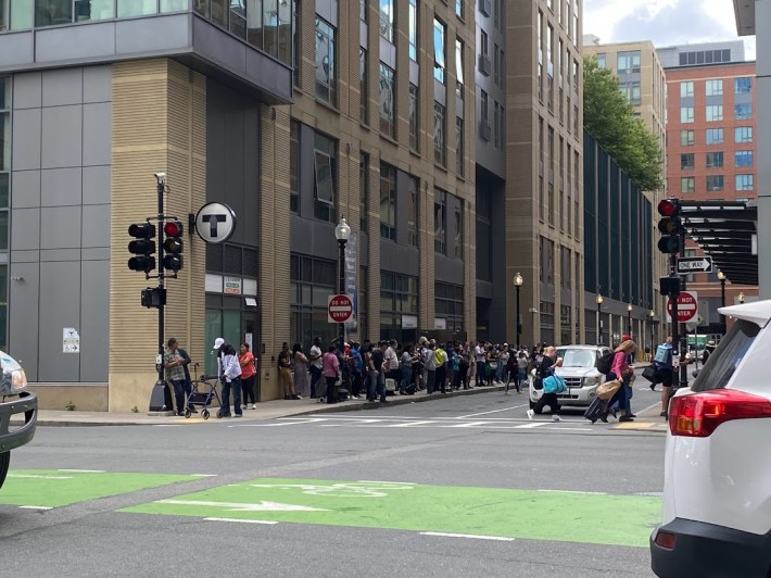 People standing in line outside North Station waiting for the shuttle bus to Government Center.