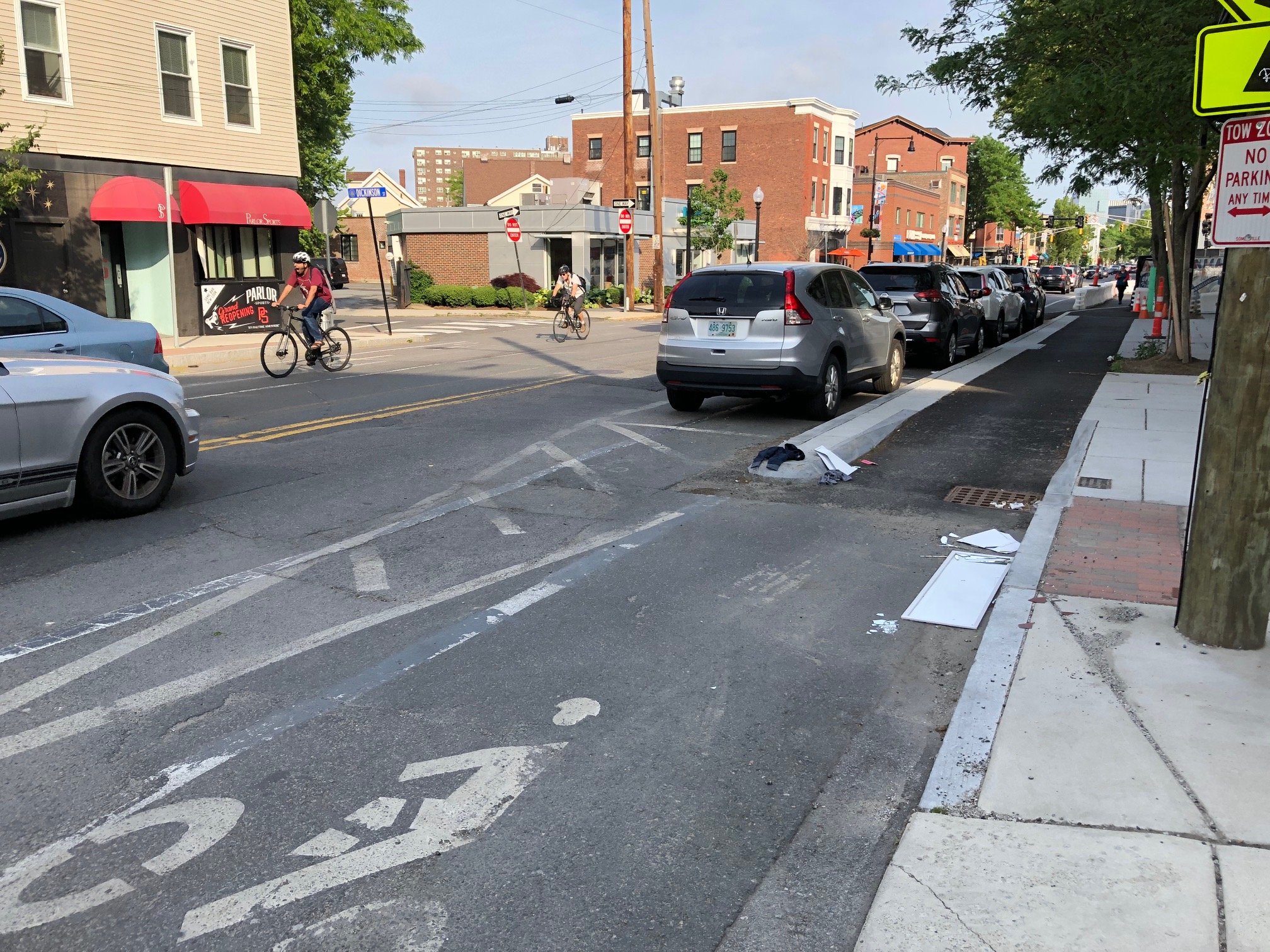 A bike rider rolls past a new protected bike lane under construction on Hampshire Street in Inman Square.