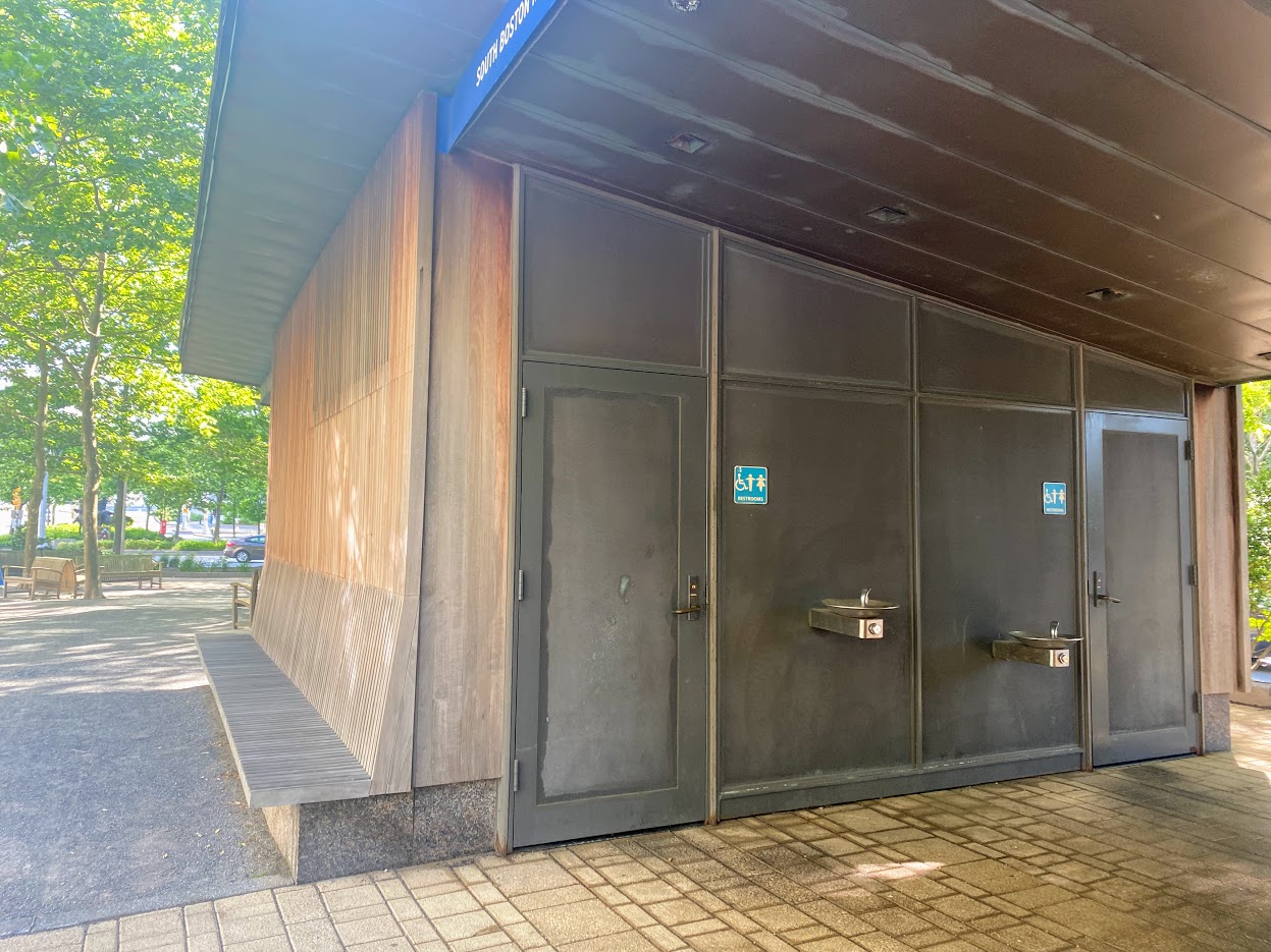 Accessible gendered public bathrooms inside the South Boston Maritime Park in the Seaport neighborhood. The park features many benches as well shade trees and two water fountains.