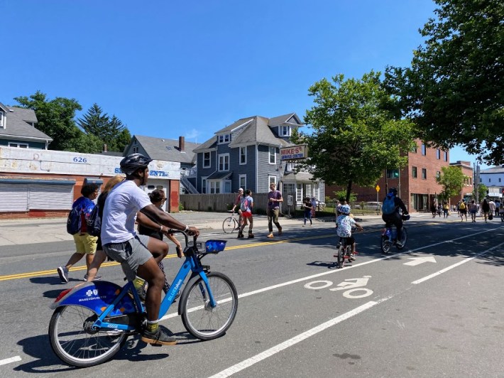 people riding bluebikes on the street