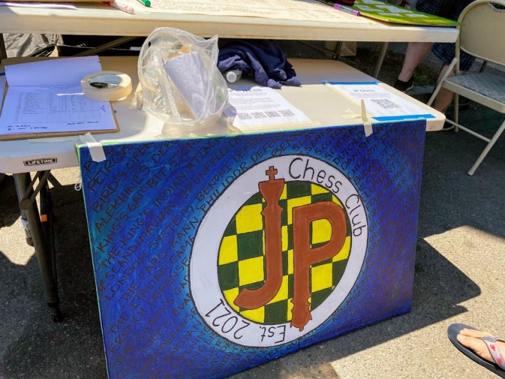 The JP Chess Club booth set up along Centre Street with flyers and details on the day's matches.