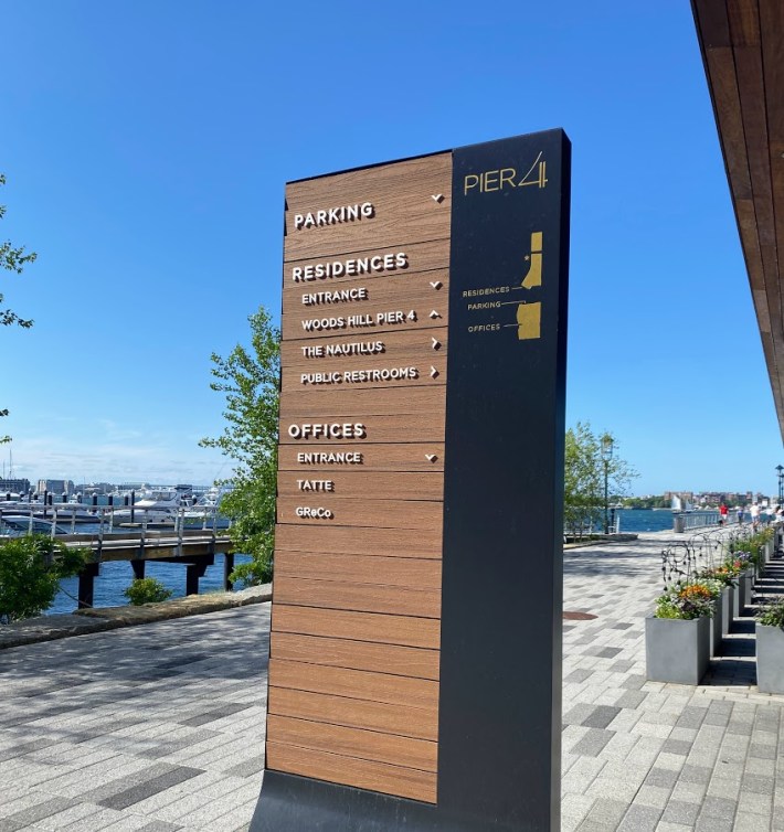 One of many wayfinding structures in the Seaport neighborhood showing the way to different amenities, including public bathrooms.
