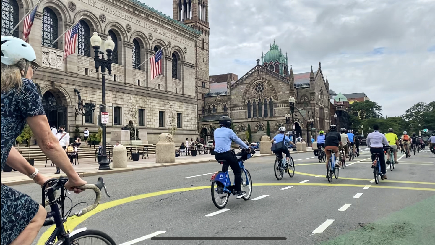 bicyclists riding past the Boston public library
