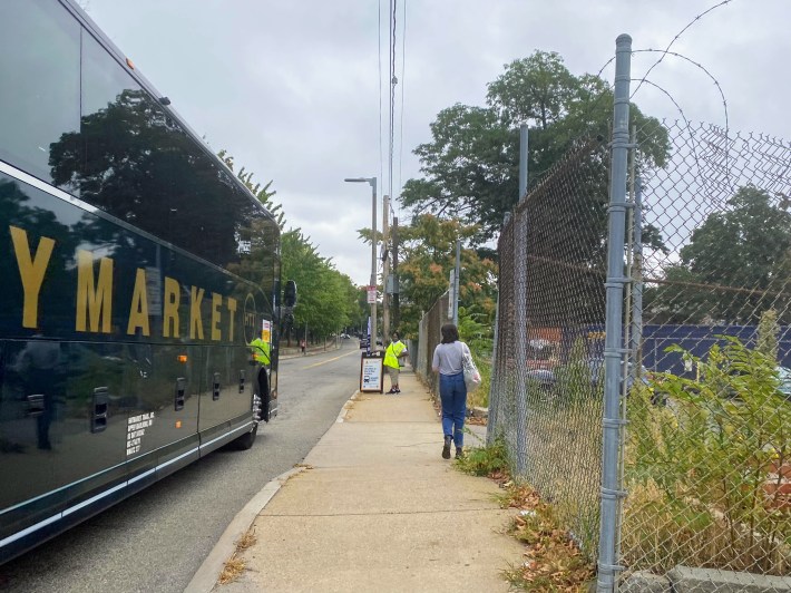 a large charter bus next to a sidewalk