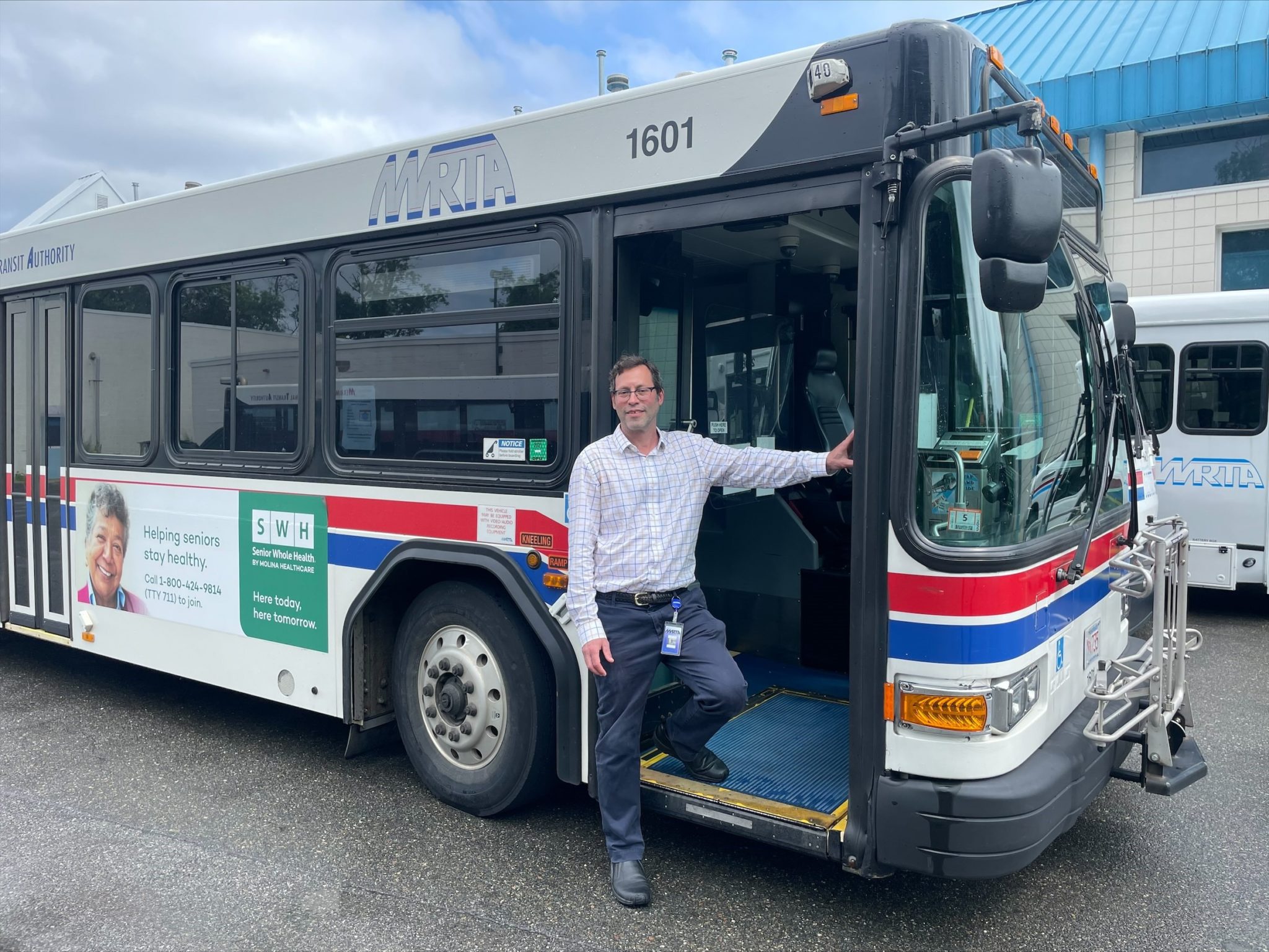 Noah Berger, administrator of the MVRTA, stands in the open doorway of an MVRTA bus.