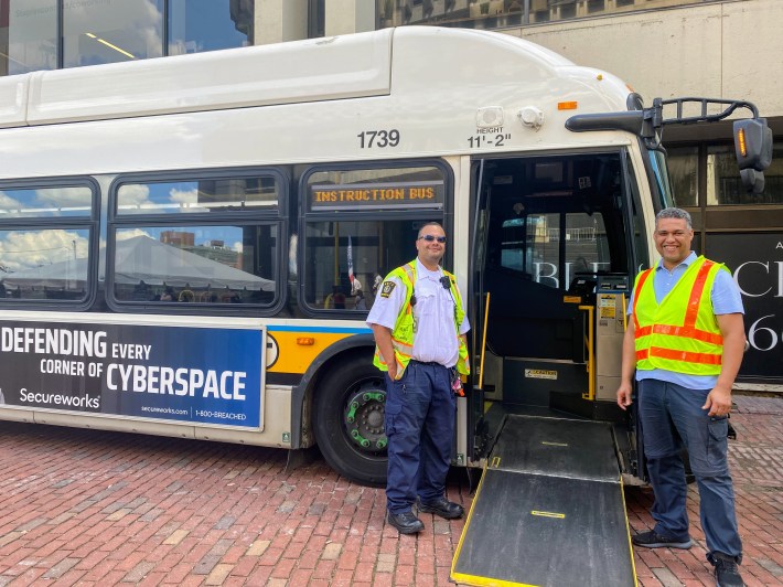 Isreal and Biadi pose infront of an MBTA bus