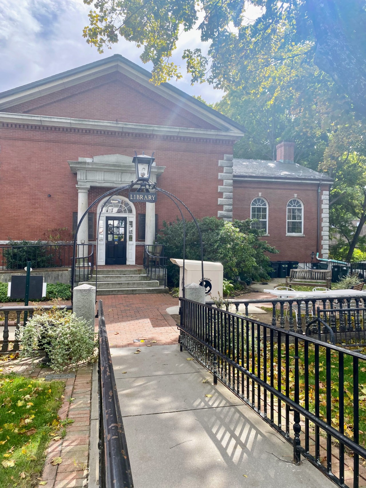 a black fenced entry way leading to a red brick building