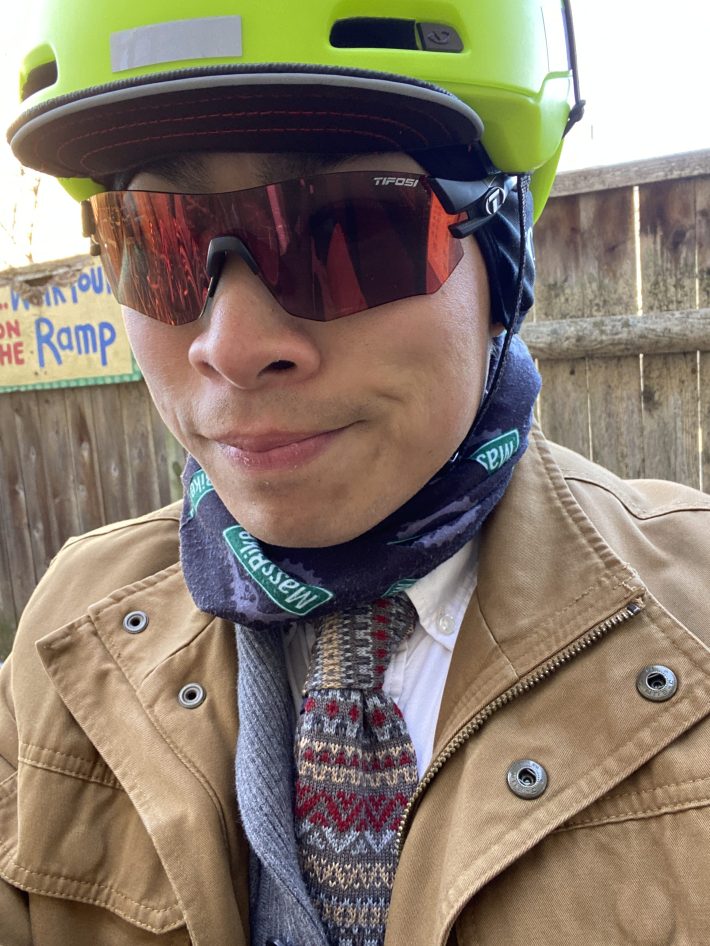 Gary Chin poses for a selfie wearing a bright helmet, sunglasses and a tan coat over multiple layers of clothing.