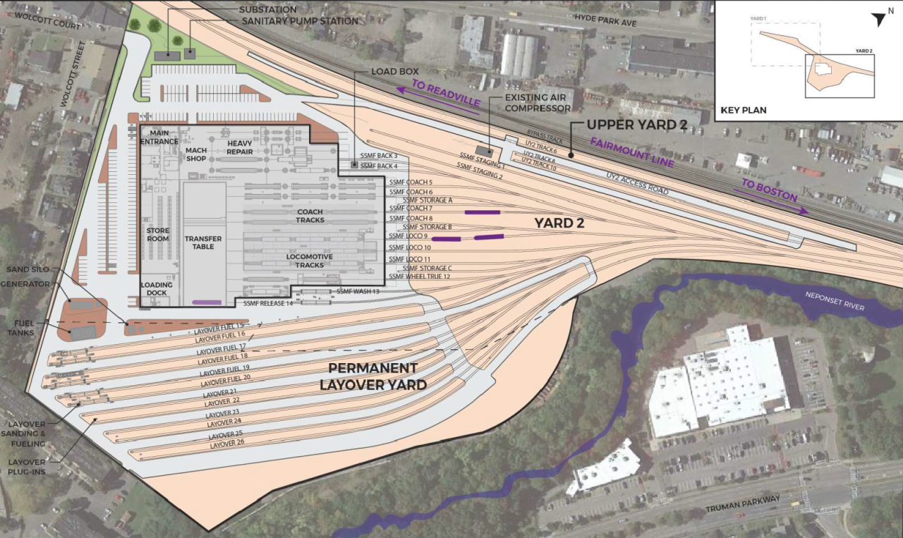 A site plan overhead view of the T's proposed South Side Maintenance Facility in Readville. The Fairmount Line tracks run horizontally across the top of the image, and the Neponset River meanders through the lower-right corner of the image. A large, roughly rectangular building outline in the center left portion of the image indicates the location of the proposed maintenance building, which includes internal space for locomotive tracks, a machine shop, a store room, and a loading dock. Below (east) of the new building are about 13 parallel lines indicating the location of a new layover yard where trains would be stored in the open air. Additional converging lines to the right (north) of the layover yard and maintenance building indicate how tracks would merge with the Fairmount Line tracks.