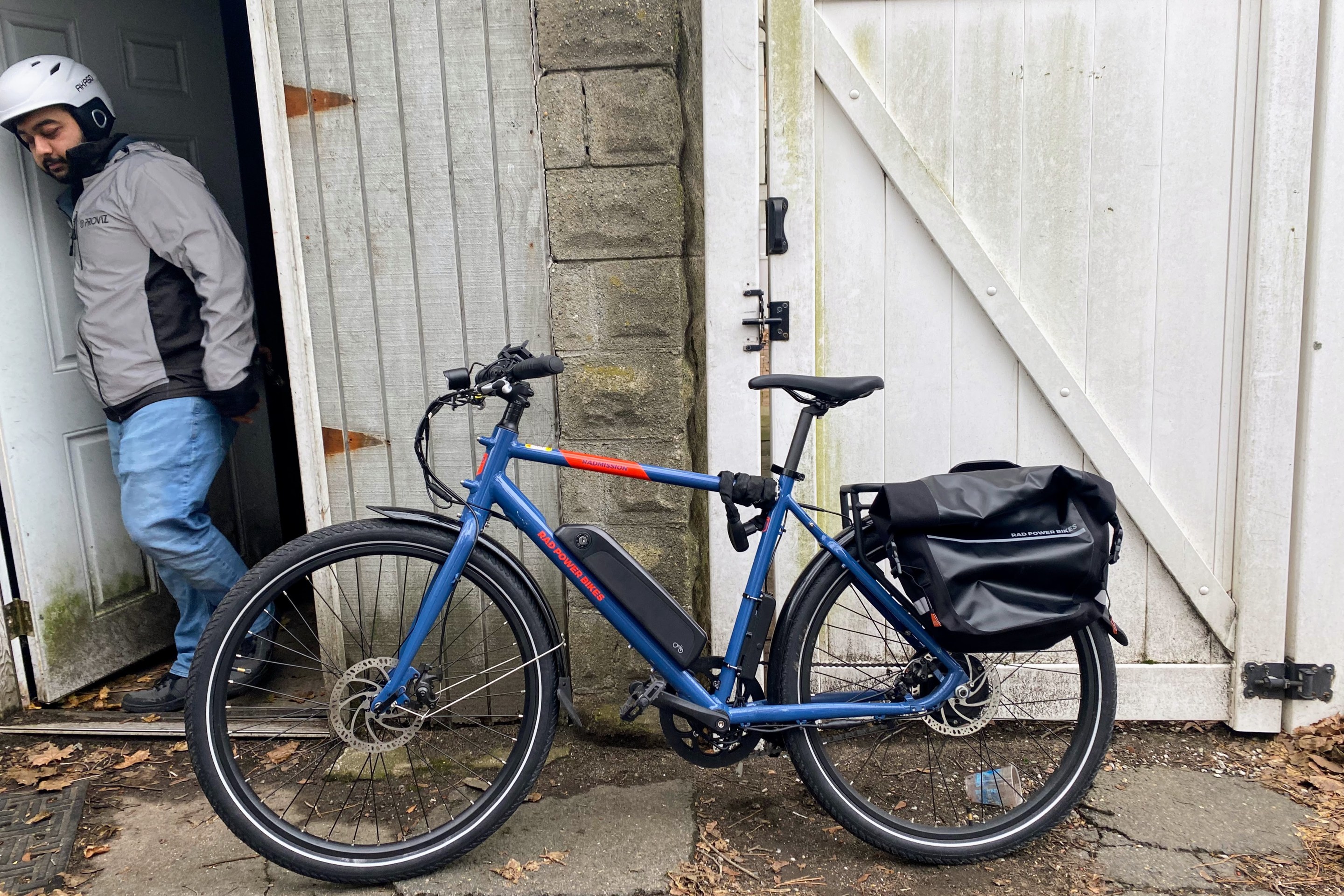 Deodhar's e-bike leans against the wall as he exits the storage shed.