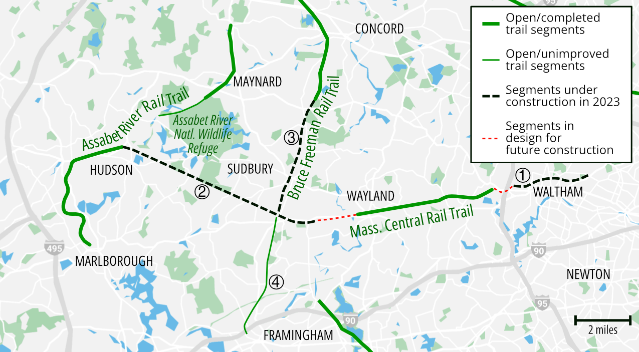 A map of the MetroWest region of Massachusetts, extending from I-495 in the west to Waltham in the east, Framingham in the south, and Concord in the north. The Mass. Central Rail Trail corridor, highlighted in green solid lines where the trail is complete and in dotted lines to indicate incomplete trail sections, crosses the center map west to east, and the Bruce Freeman Rail Trail crosses the center of the map north to south.