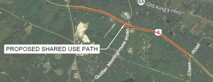 A satellite view of part of the Town of Sandwich highlighting a proposed shared-use path, highlighted as a red line that runs generally east-west (left to right) alongside the Route 6 highway through the middle of the image.