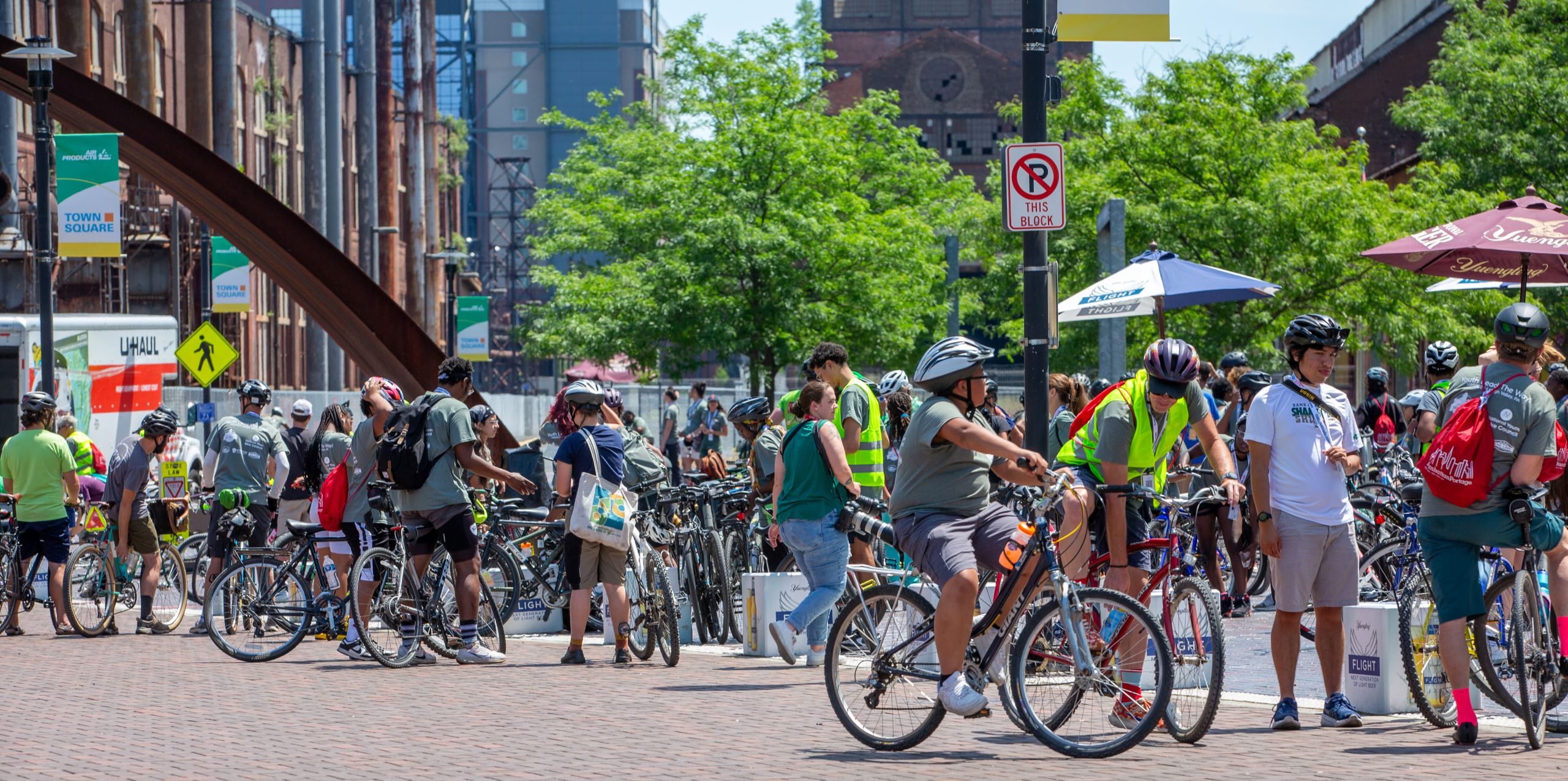 A crowd of young people on bikes in a large plaza.