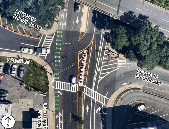 Aerial image of the intersection of Main Street, South Street, and the Route 16 eastbound on- and off-ramps. Includes bike lanes, crosswalks, lane markings, and construction cones.