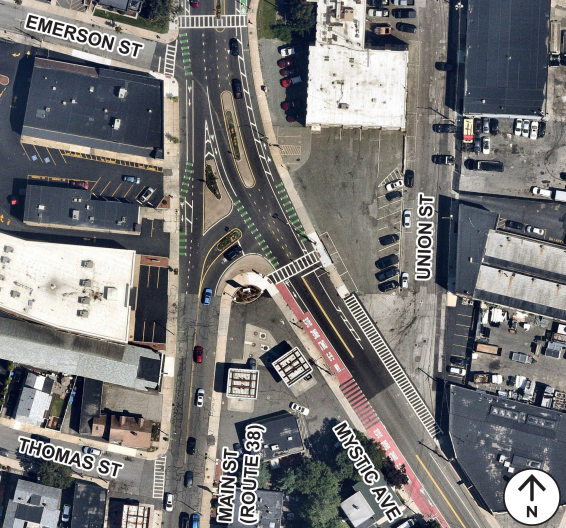 Aerial view of the existing signalized intersection of Main Street and the Route 16 westbound on- and off-ramps at the Mystic River. Features marked crosswalks and signal infrastructure.