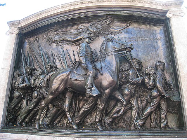 A bronze sculpture depicting Colonel Robert Gould Shaw on horseback leading the all-Black 54th Regiment Massachusetts Volunteer Infantry marching down Beacon Street on May 28, 1863 to fight in the Civil War. The monument is framed by a stone arch.