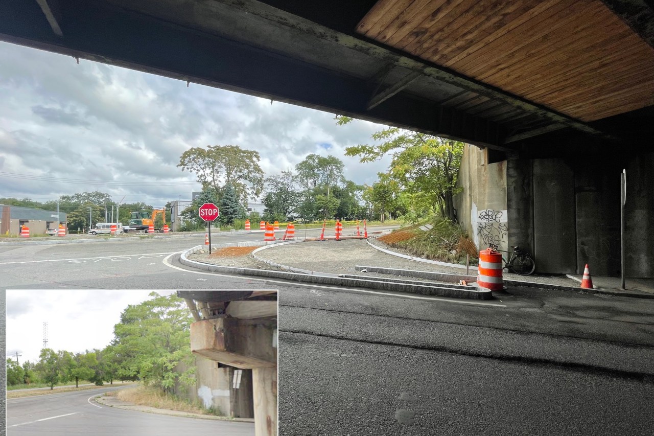 A highway construction site under a highway overpass which looms in shadow over the top edge of the photo. New granite curbs have been installed in the middle of an older roadway in the center of the photo, curving at a road junction. An inset at lower left shows what the same scene looked like before construction, when there was a much narrower sidewalk at the corner.