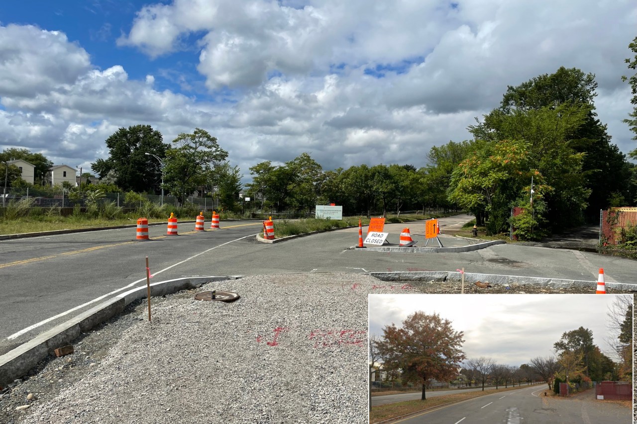 A highway construction site. New granite curbs have been installed in the middle of an older roadway with a path of packed gravel visible in the foreground. Several orange construction barrels dot the roadway. An inset at lower right shows what the same scene looked like before construction, when the same view looked down two lanes of a four-lane divided highway.