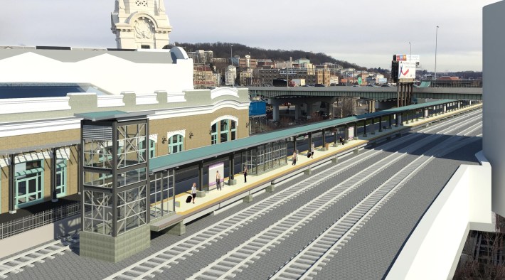 A rendering of a new train platform in front of the Worcester skyline next to the historic Worcester Union Station (at left), showing a fence blocking the station-side platform from the station-side track.