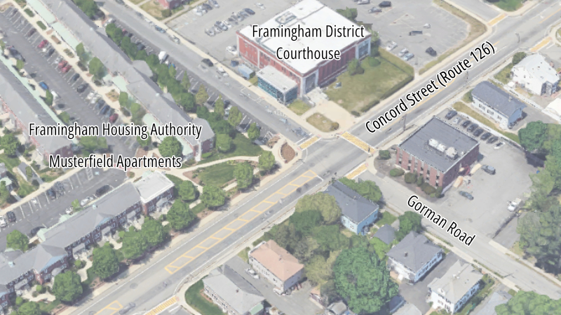 A bird's eye view of an intersection in a residential suburban neighborhood. One street crossing diagonally from lower left to upper right is labelled Concord Street. An intersecting street from the center of the image to lower right is labelled Gorman Road. A building near the top of the image, facing the intersection of those two streets, is labelled Framingham District Court House. A complex of apartments near the left edge is labelled Framingham Housing Authority Musterfield Apartments