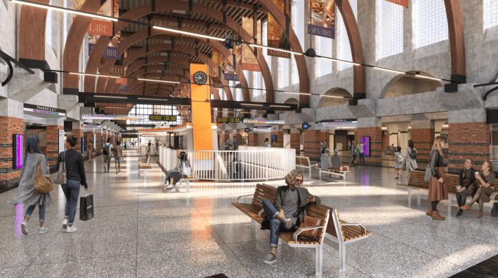 A rendering of the Back Bay Station's main hall. A tall, orange pillar holds a large analog clock. Commuters walk through the station while others sit on new benches under large arches.
