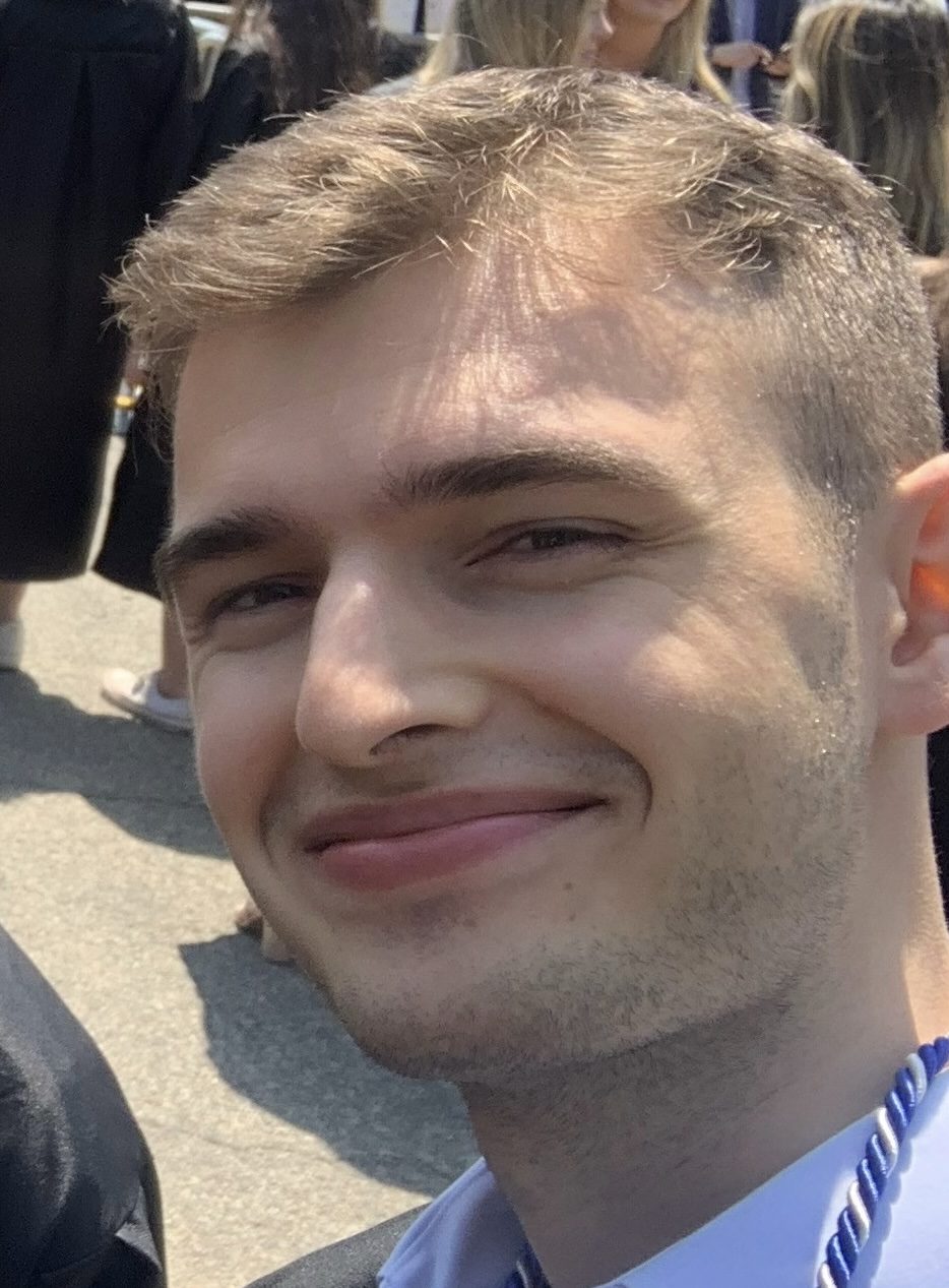 A young man with light-colored skin and short brown hair.